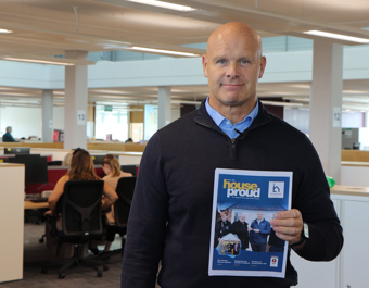 Chris Margrave holding Annual Review cover
